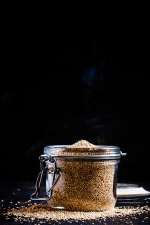 Quinoa in a jar on black background, selective focusの写真素材