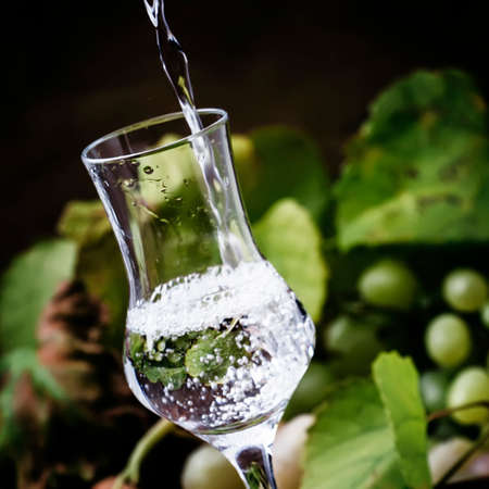 Strong Alcoholic Drink Being Poured Into Shot Glass, Rustic Still Life, Selective Focus and Shallow DOFの写真素材