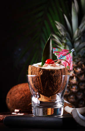 Pina Colada Cocktail in chopped coconut with tropical fruits and bar tools, summer relax concept, copy spaceの写真素材