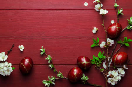 Easter eggs and spring white flowers on Easter red wood background with copy spaceの写真素材