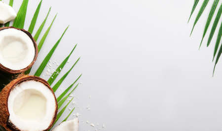 Coconut and pieces of coconut on gray background, top view, copy space