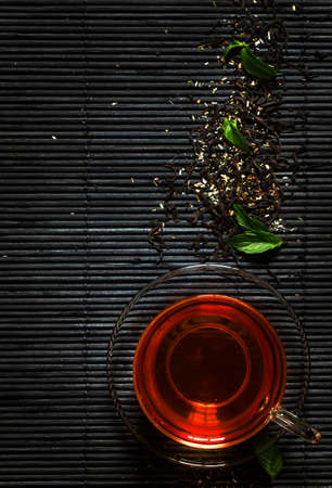 Black hot tea with mint on gray mat, copy space, top viewの写真素材