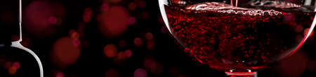 Red wine on black background, abstract splashing. Panoramic banner with copy spaceの写真素材