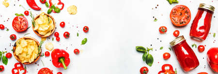 Potato chips with salt and rosemary with tomato juice, chili and pepper, spices and green basil, top view. Panoramic banner with copy spaceの写真素材