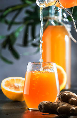 Homemade Fermented Raw Kombucha With Ginger And Lemon Pouring Into Glass. Superfood drink.Tea Ready...