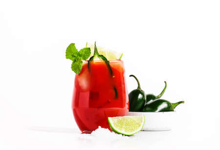 Spicy alcoholic cocktail with vodka, tomato juice, jalapeno pepper, lime and salt, white background,...