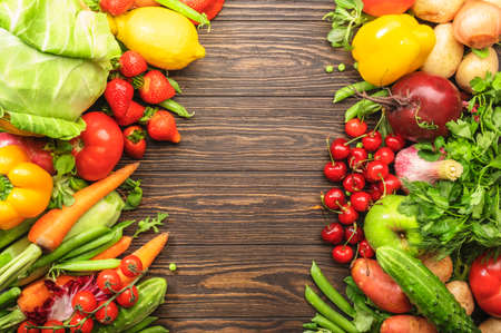Assortment of fresh vegetables and fruits on wooden table background. Healthy organic food concept