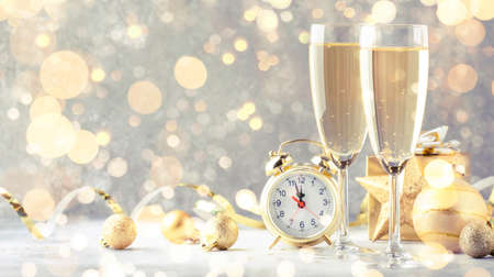 Two champagne glasses and christmas decoration over gray golden bokeh background. Happy New Year Celebration. Selective focus and small depth of fieldの写真素材