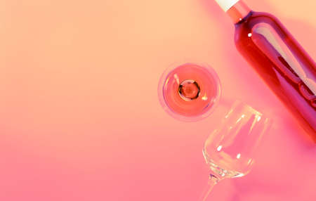 Rose wine glass with bottle on pink bakcground. Rosado, rosato or blush wine tasting in wineshop, bar concept. Copy Space, top viewの写真素材
