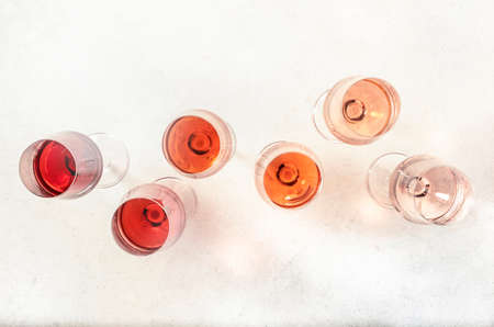 Rose wine glasses set on wine tasting. Degustation different varieties, colors and shades of pink wine concept. White background, top viewの写真素材