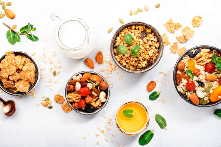 Muesli bowl, organic ingredients for healthy breakfast Granola, nuts, dried fruits, oatmeal, whole grain flakes on white background.の写真素材