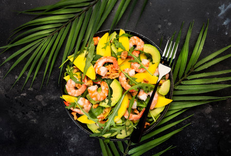 Shrimps, Mango and Avocado Salad with Walnut, Spinach and Arugula. Healthy Eating food concept Top view, gray backgroundの写真素材
