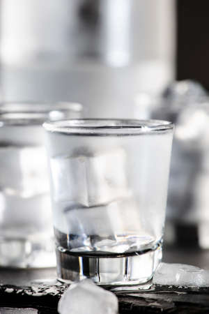 Cold Vodka in shot glasses on black background, ready to drinkの写真素材
