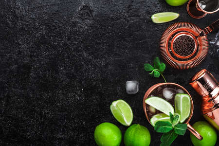 Moscow Mule. Preparation cocktail with ginger beer, vodka, lime and ice. Copper bar tools. Black bar counter. Top viewの写真素材