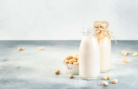 Cashew nut milk in bottles on white background. Non dairy alternative vegan milk. Healthy vegetarian and diet food and drink conceptの写真素材