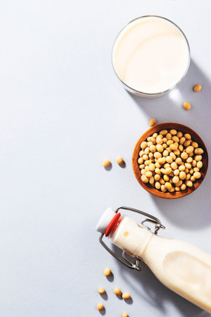 Vegan Soy milk and bean on gray table background. Non dairy milk concept. Diet drink. Hard light. Copy spaceの写真素材