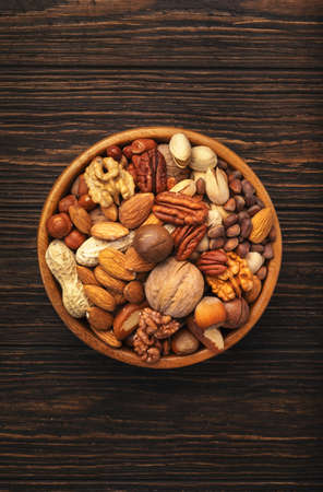 Nuts in bowls. Walnuts, pistachios, pecans, macadamia, almonds and other. Healthy food snacks mix on...