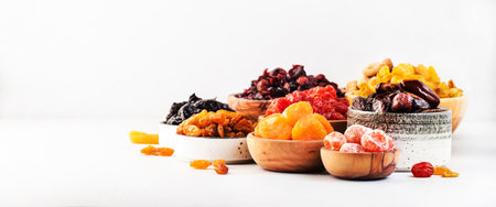 Healthy food snacks: natural dried fruits mix in bowls on white backgroundの写真素材