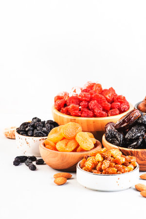 Assortment of nuts and dried fruits. Healthy snacks. Dried apricots, figs, raisins, pecans, walnuts, hazelnuts, almonds and other. White backgroundの写真素材