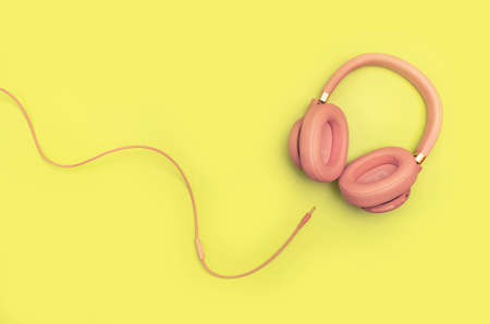 Pink Wireless Headphones on yellow background. Trendy minimal style. Music concept. Flat lay banner with copy space, top viewの写真素材