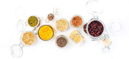 Grocery, home stocks in plastic free storage and jars. Various beans, grains, cereals, legumes, seeds in reusable cans. White table. Zero waste and sustainable llifestyleの写真素材