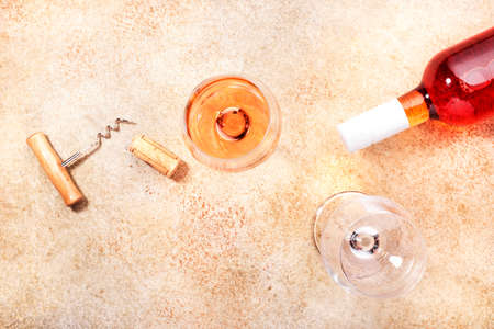 Rose wine glass with bottle on the beige table. Copy Space, top viewの写真素材