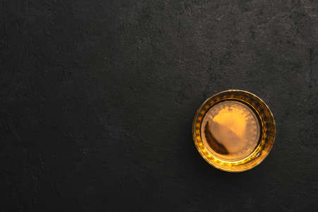 American bourbon whiskey in glass, black background with negative space