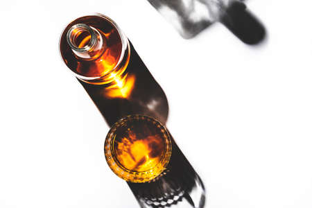 American bourbon whiskey in glass and bottle, white background with shadow pattern and negative space. Hard lightの写真素材