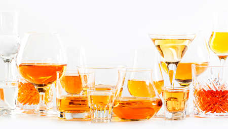 Strong alcohol drinks, hard liquors, spirits and distillates iset in glasses: cognac, scotch,...