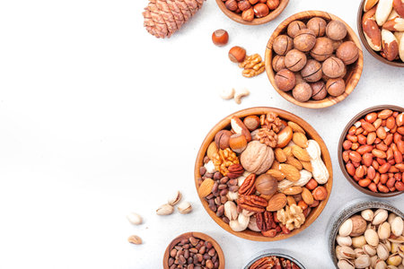 Nut mix in bowl. Almonds, hazelnuts, walnuts and other. Healthy food snack mix on white table, top view, copy spaceの写真素材