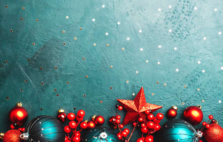 Blue Christmas or New Year background with blue Christmas balls, red berries and stars, top view, place for textの写真素材
