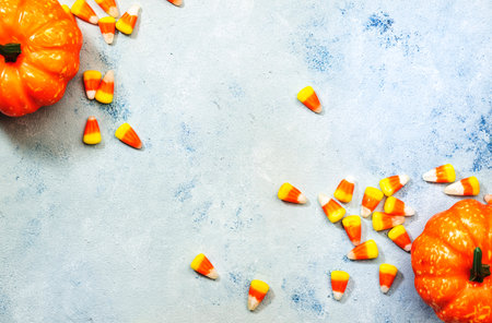 Halloween pumpkin and candy corn banner on blue baclground. Top view with copy space