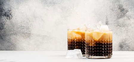 White russian cocktail, trendy alcoholic drink with vodka, coffee liqueur, cream and ice, gray...