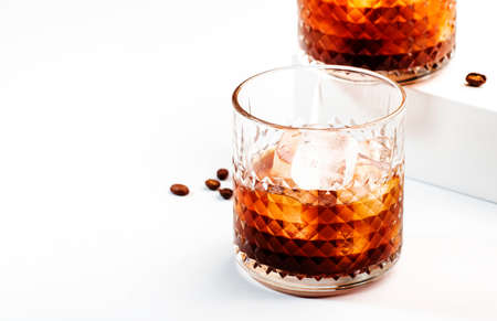 Black russian cocktail, trendy alcoholic drink with vodka, coffee liqueur and ice, white background,...