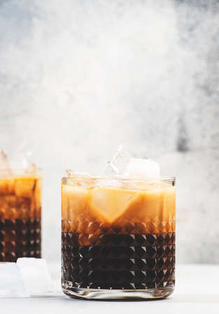 White russian cocktail, trendy alcoholic drink with vodka, coffee liqueur, cream and ice, gray backgroundの写真素材