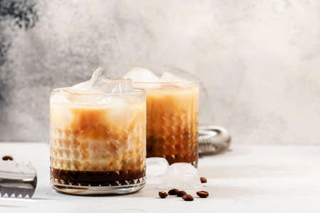 White russian cocktail, trendy alcoholic drink with vodka, coffee liqueur, cream and ice, gray background, bar tools, copy spaceの写真素材