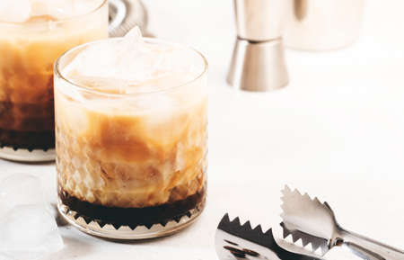 White russian cocktail, trendy alcoholic drink with vodka, coffee liqueur, cream and ice, gray...