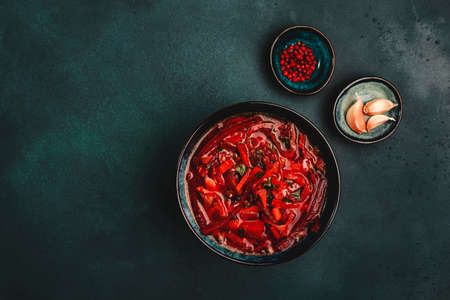 Traditional homemade red cabbage soup with beets, vegetables and herbs, Russian borscht in plate on blue kitchen table background, top view, copy space. Vegan, vegetarian healthy diet local foodの写真素材