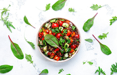 Quinoa tabbouleh salad with tomatoes, paprika, avocado, cucumbers and parsley. Traditional Middle Eastern and Arabic dish. White kitchen table background, top viewの写真素材