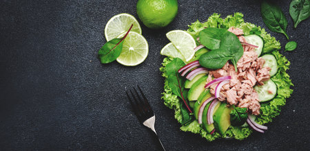 Tuna fish salad with avocado, cucumber, red onion, spinach and lettuce. White stone background, top view, copy spaceの写真素材