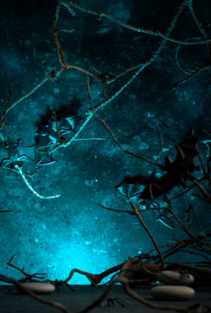 Halloween scary dark blue background with twisted branches, bats, stones and spiders, copy spaceの写真素材