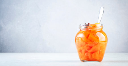 Quince jam or confiture in glass jar with cinnamon and anise on gray kitchen table background, copy space bannerの写真素材