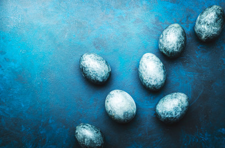 Easter composition with blue painted eggs on blue background, top viewの写真素材