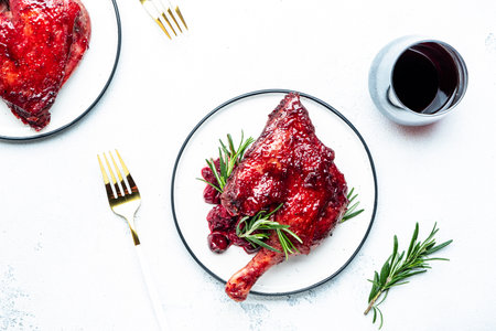 Baked duck legs in cherry red wine sauce with rosemary. Delicacy dinner. White table background, top viewの写真素材