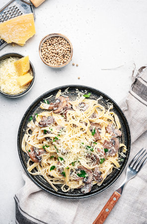 Prepared pasta with mushrooms with parsley and cheese on gray table background, top view. Healthy cooking and eating. Italian food conceptの写真素材