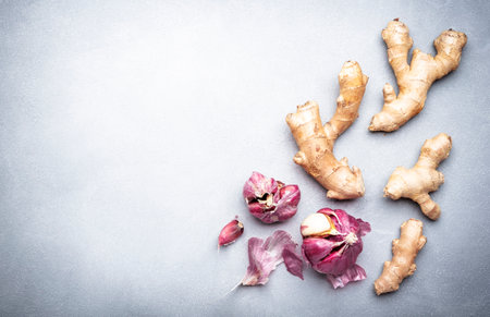 Fresh ginger root and purple garlic. Gray kitchen table background, top view, copy spaceの写真素材