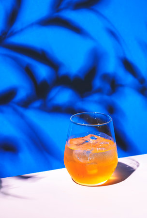 Bee's Knee cocktails drink with dry gin, lemon juice and honey syrup, blue background, bright hard light and shadowsの写真素材