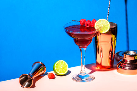 Raspberry daiquiri alcoholic cocktail with rum, syrup, fruit juice, lime, berry and ice in glass....
