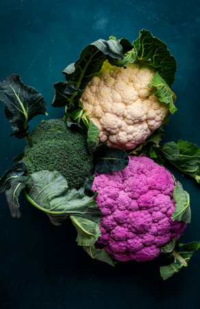 Purple and white cauliflower, broccoli cabbage from farm market on old rustic green table, top viewの写真素材