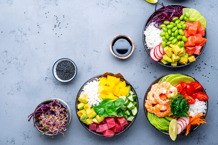 Poke bowl for balanced nutrition. Set with tuna, salmon, shrimp avocado, mango, radish, white rice and other ingredients. Gray table background, top viewの写真素材